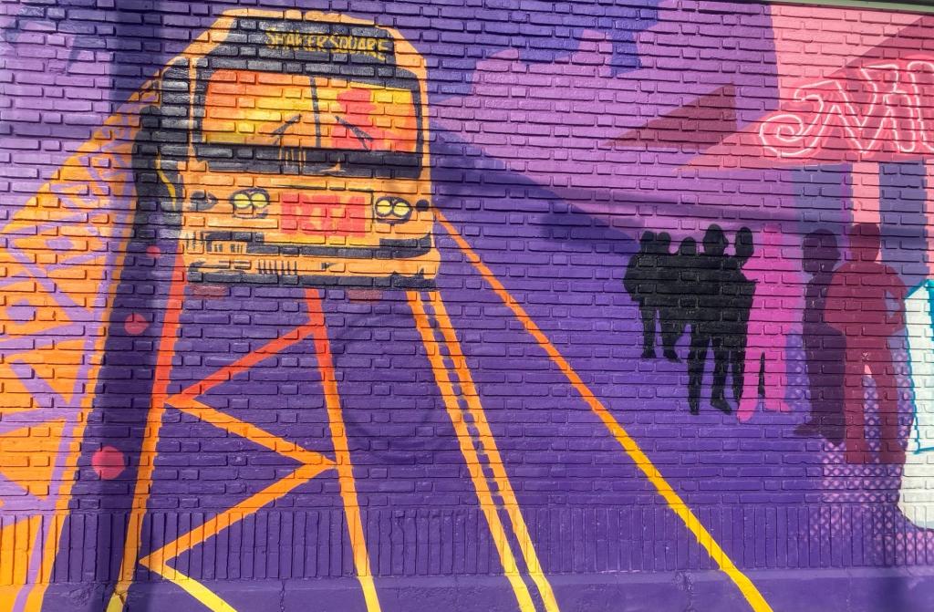 Located on GCRTA’s 700ft wall outside of the Central Bus Maintenance Facility, the mural, a part of the Elevate the East public art plan, depicts the history of the neighborhood, highlighting people, places, and events that are important to the people living in this neighborhood. It is a colorful depiction that chronicles the life of the people who live, lived, grew up, or worked in this area. It allows GCRTA infrastructure to create canvases that celebrate community spirit. Unveiled October 25, 2024. 