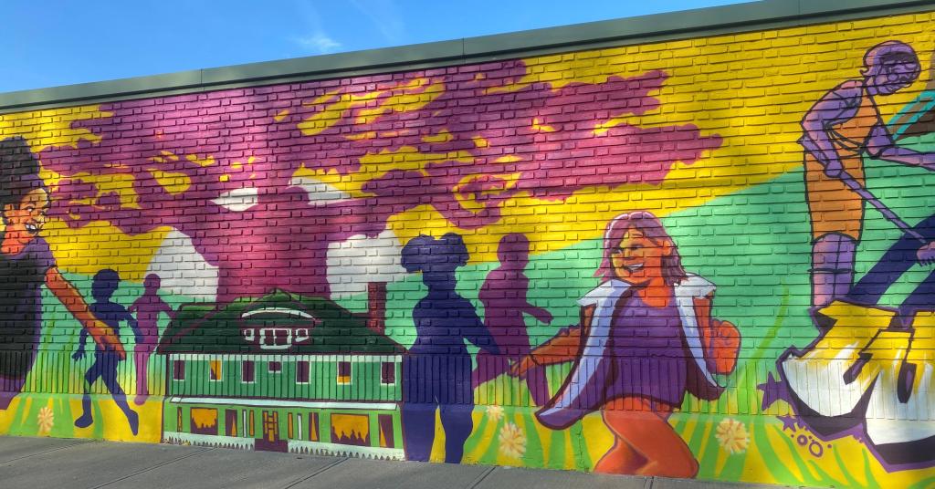 Located on GCRTA’s 700ft wall outside of the Central Bus Maintenance Facility, the mural, a part of the Elevate the East public art plan, depicts the history of the neighborhood, highlighting people, places, and events that are important to the people living in this neighborhood. It is a colorful depiction that chronicles the life of the people who live, lived, grew up, or worked in this area. It allows GCRTA infrastructure to create canvases that celebrate community spirit. Unveiled October 25, 2024.